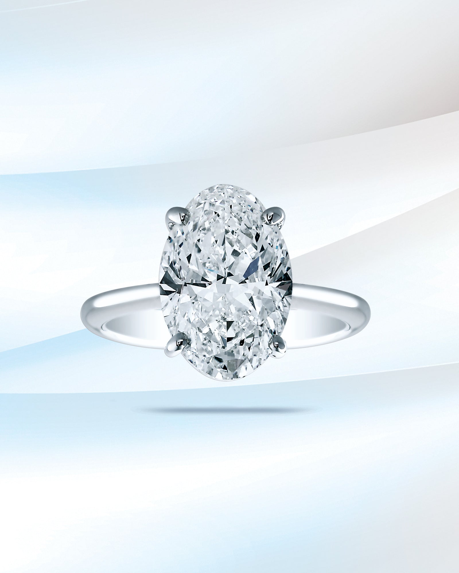 An oval diamond ring on pale blue silk.