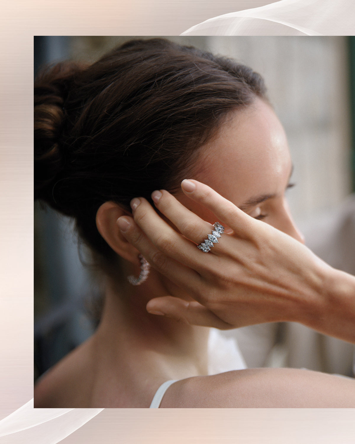 She gathers her hair, a diamond band on her hand.