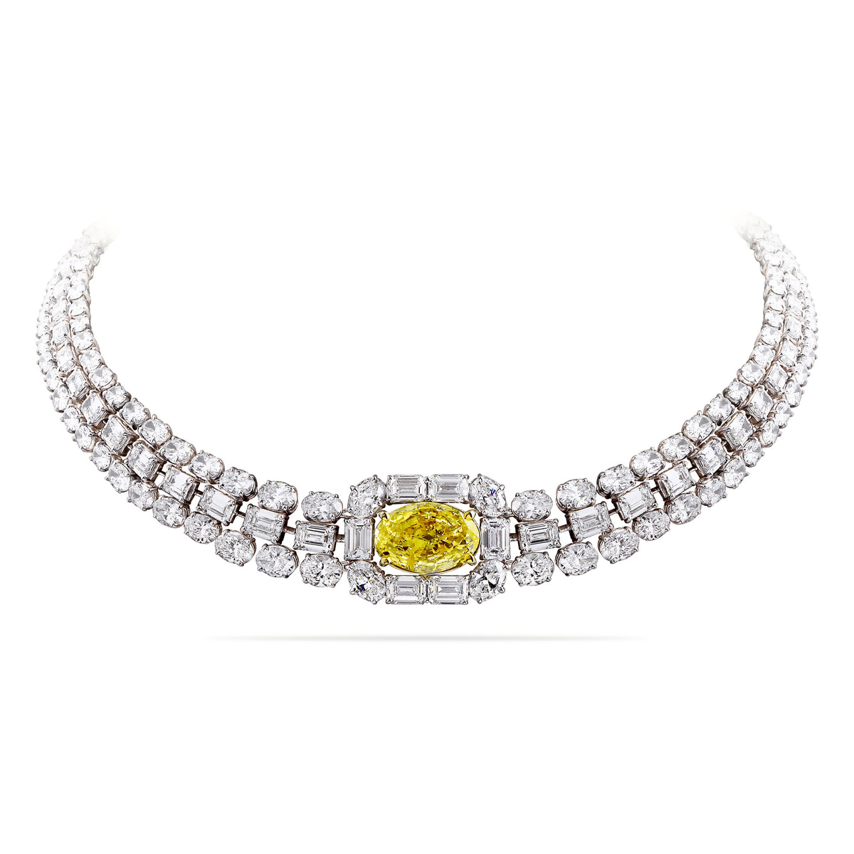 Un collier de trois rangs de diamants centré sur un diamant jaune Fancy de taille ovale, encadré de diamants taille émeraude et taille ovale.
