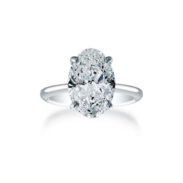 An oval diamond solitaire held in four double-claw prongs on a plain polished white gold band.